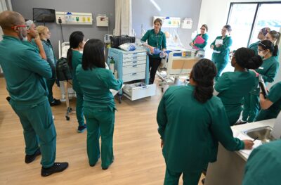 Nursing Students Participating in a Clinical Skills Training Session Led by an Instructor in a Simulation Lab