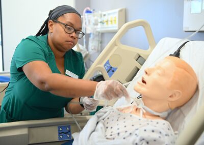 Student Nurse Practicing Clinical Skills on a Mannequin in a Medical Simulation Lab
