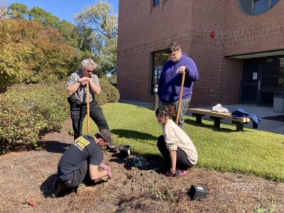 FTCC's Science Club works in the pollinator garden near the Health Technologies Building.