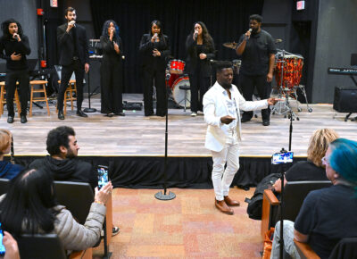 Stephen Love sings in front of a stage before the audience.