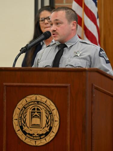 BLET graduate Joshua Marquis, dressed in uniform, speaks at the podium.