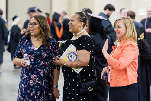 Dr. Tiffany Watts, Dr. DeSandra Washington and Dr. Murtis Worth smile at graduates in the staging area.