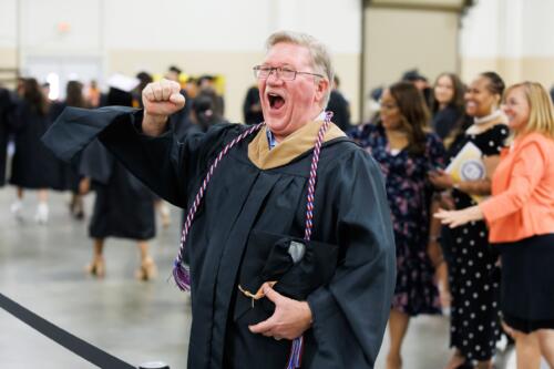 Jessie Bellflowers, dressed in graduation regalia, yells in excitement.