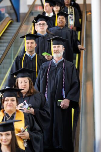 Graduates descend the escalator.