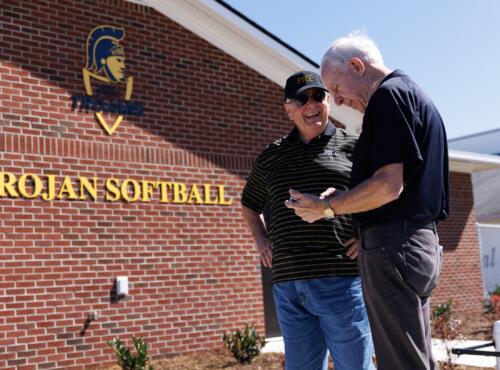 Larry Keen and Charles Koonce stand outside the Trojan Softball Fieldhouse.