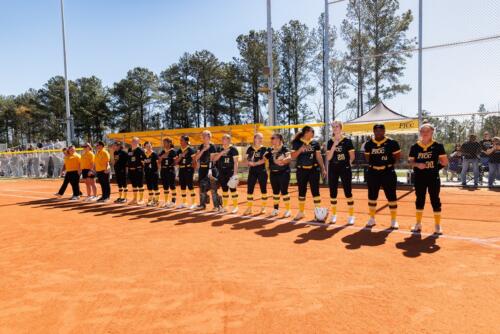 The FTCC softball team lines up along the first base line for the singing of the national anthem.