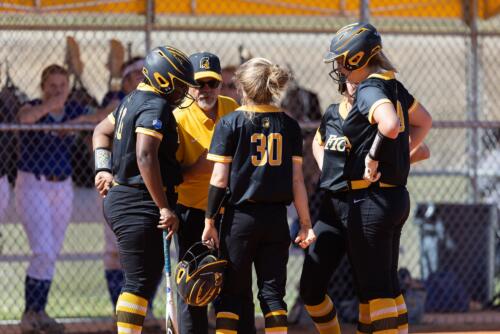 FTCC softball players huddle around coach John Newman.