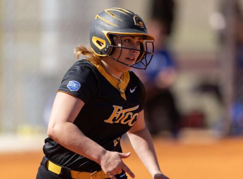 A close-up photo of a FTCC softball player running to first base.