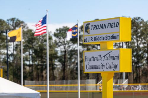 Yellow and white marquee next to the flag poles at JP Riddle Stadium.