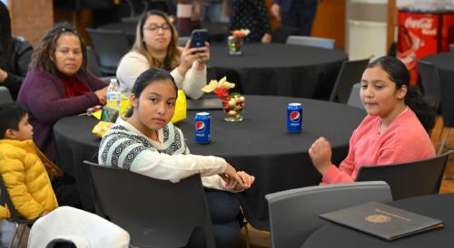 Family members of graduates sit at the graduation for the Spanish Language Electrical Program.